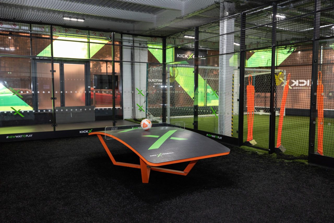 4 players playing 2v2 Teqball, a hybrid of football and table tennis